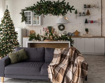 Modern kitchen interior with Christmas tree and sofa.
