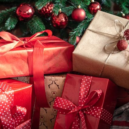 Close up of red gift boxes near the Christmas tree.