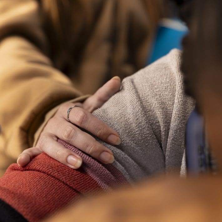 Young adult trying to wake up african american girl in the university library