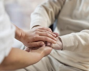 Doctor holding hands with senior patient